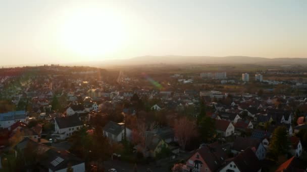 Batan güneşe karşı küçük bir kasabanın hava aracı görüntüsü. Sakin bir akşam atmosferi. Kötü Vilbel, Almanya. — Stok video