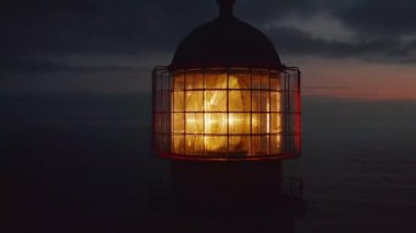 Alacakaranlıkta parlayan deniz feneri fresnel lenslerini kapatınca etrafta dolaşan dron sansasyonel akşam deniz manzarasını, Lagos 'u, Portekiz' i gözler önüne seriyor.