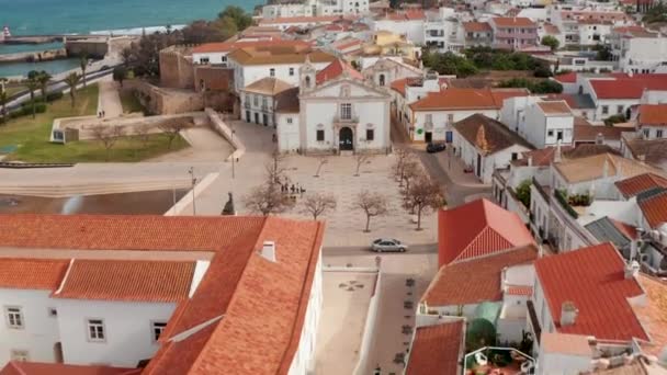 Malerische Drohnenaufnahme aus der Luft über dem Stadtzentrum der Hafenstadt Lagos, Portugal, mit Blick auf Kirche und Stadtplatz. Dolly vorwärts, sonniger Tag — Stockvideo