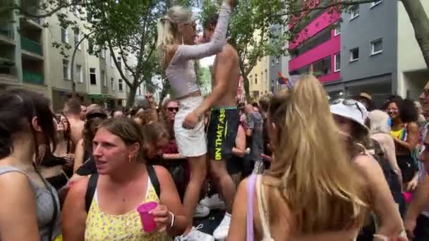 Transseksualistka pokazująca klip do smartfona mężczyźnie bez koszulki podczas stania i tańczenia na podium podczas świętowania wolności i dumy w The Christopher Street Day w Berlinie, Niemcy — Wideo stockowe