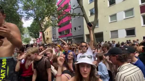 Молодой мужчина без рубашки проверяет женский смартфон, танцуя на подиуме и куря сигарету, празднуя свободу и гордость в День Кристофер-стрит в Берлине, Германия — стоковое видео