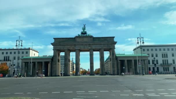 Auto rijdt op de Strasse des 17. Juni straat na verkeersstop bij de Brandenburger Tor in Berlijn, Duitsland, omgeven door bouw- en herfstbomen overdag — Stockvideo