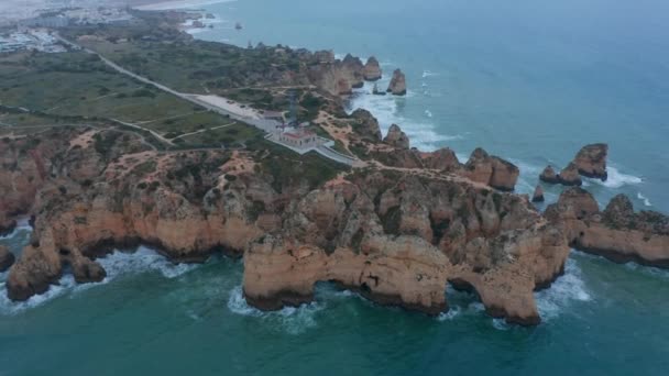 Espetacular vista aérea drone de Lagos, Portugal costa oceano com farol e paisagem urbana no fundo, dia, círculo pan — Vídeo de Stock