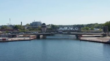 İleri su yüzeyinin üzerinden uçar. Köprüde yoğun trafik var. Parmaklıkları olan boş bir rıhtım. Berlin, Almanya