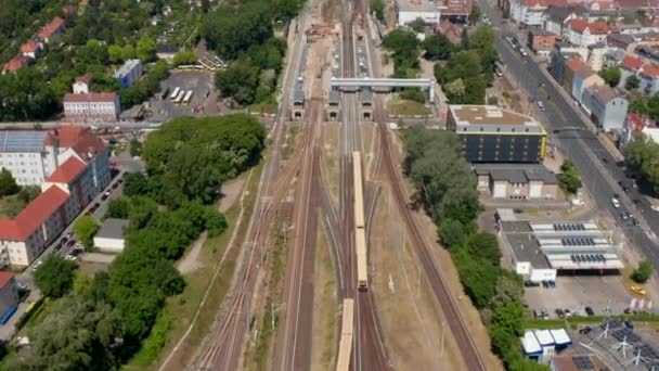 Aerial view of S bahn train driving to Schoneweide train station. Maintenance and modernization of transport infrastructure. Tilt up reveal of city. Berlin, Germany — Stock Video