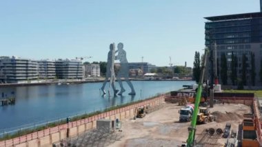 Forvetler Molekül Adam 'a uçuyor, Spree Nehri' nde 30 metre yüksekliğinde heykel. Birbirine yaslanmış üç insan silueti. Berlin, Almanya