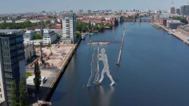 In avanti volano verso Molecule Man vicino alla riva del fiume Sprea. Scultura di tre sagome umane in materiale irregolarmente perforato. Berlino, Germania — Video Stock