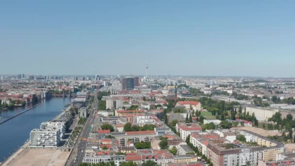Лети над городом. Воздушный вид на городские кварталы на реке Спри. Телебашня Фернзехтурм на расстоянии. Берлин, Германия — стоковое видео