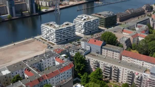 Hacia adelante y la inclinación hacia arriba revelan de la escultura Molecule Man en el río Spree y gran panorama de la ciudad. Día soleado con cielo despejado. Berlín, Alemania — Vídeo de stock