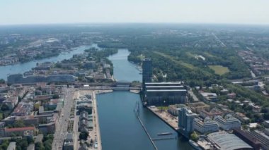Havadan eğil ve Treptower binası kompleksi ve Molekül Adam heykeli Spree nehrinde. Berlin, Almanya