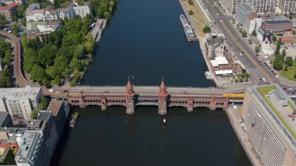 Vista aérea del tren U bahn cruzando el histórico puente de Oberbaum. Antiguo puente de dos pisos con torres al lado del puente de carretera. Berlín, Alemania — Vídeo de stock