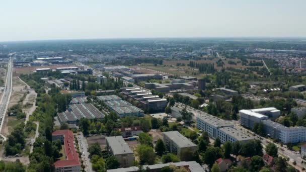 Hacia adelante vuelan por encima del parque industrial o logístico en los suburbios. Edificios con filas de tragaluces en la azotea. Paisaje plano. Berlín, Alemania — Vídeo de stock