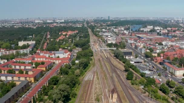 Incline-se para baixo imagens de linha ferroviária em linha reta que leva através do bairro urbano. Vista aérea do tráfego em via férrea, passando por comboios. Berlim, Alemanha — Vídeo de Stock
