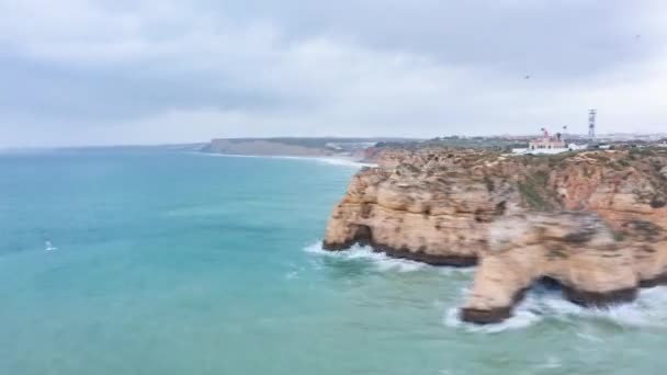 공중 드론 하이퍼가 바위 절벽에 부딪치는 파도와 함께 아름다운 라고스 알가르브 해안선을 선회하며 구름낀 하루의 하이퍼 랩 — 비디오