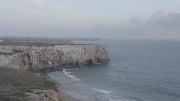 Vistas aéreas deslumbrantes de Lagos Algarve litoral rochoso penhasco, ondas colidindo contra a costa, voo lateral, Portugal, dia — Vídeo de Stock