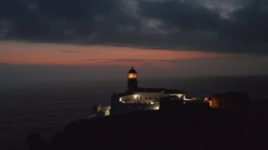 Portekiz, Lagos Algarve 'deki Ponta da Piedade Deniz Feneri' nin güzel hava manzarası, İHA 'lar sarı fresnel lenslere doğru ilerliyorlar, akşam alacakaranlığı.