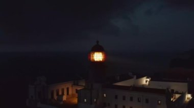 Portekiz, Algarve 'deki Ponta da Piedade Deniz Feneri' nin güzel hava aracı manzarası, akşam üstü alacakaranlıkta daire şeklinde.