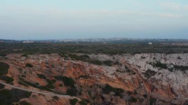 Lagos Algarve, Portekiz 'deki kayalık renkli uçurumlar arasında gizlenmiş tenha kumsal manzarası.