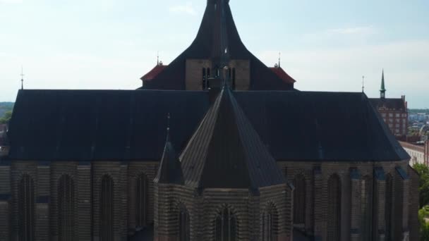 Voorwaarts vliegen over het dak van de kerk Saint Marys. Baksteen gotische stijl gebouw met torentjes — Stockvideo