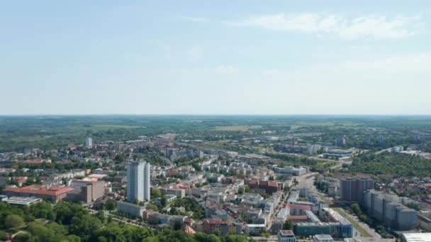 Aerial view of residential urban neighbourhood with train station in distance. Town in flat coastal landscape — Stockvideo