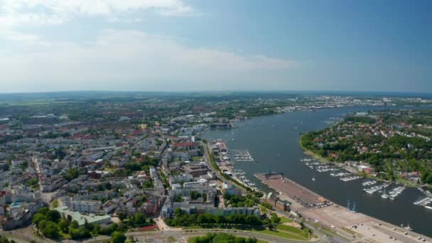 Aerial panoramic view of town on riverside of Unterwarnow river. Boats moored in marina — Stockvideo