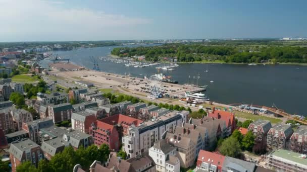 Aerial view of coastal urban district with various colourful houses and large parking lot with Ferris wheel attraction on waterfront — Stock Video