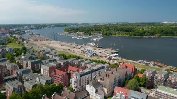 Aerial view of coastal urban district with various colourful houses and large parking lot with Ferris wheel attraction on waterfront — Stockvideo