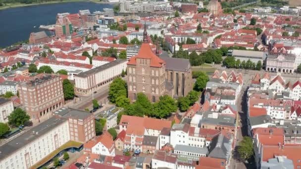 Descending tilt up view of town on riverside. Saint Marys and Saint Peters churches towering over surrounding buildings — Stock Video