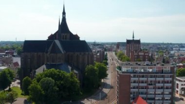 İleride tramvay rayları olan uzun ve düz bir cadde var. Saint Mary Kilisesi 'nin büyük tuğla binasının etrafında uçun.