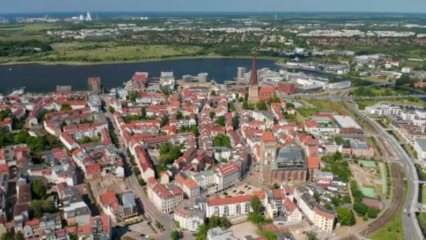 Fly above historic town centre next to sea bay. aerial panoramic view of streets lined by buildings with red tiled roofs — Stock Video