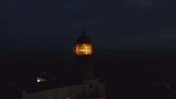 Close-up van de stralende vuurtoren gele fresnel lens hoofd bij schemering in Lagos Algarve, Portugal, antenne drone cirkelen rond, 's avonds — Stockvideo