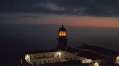 Portekiz, Lagos Algarve 'deki Ponta da Piedade Deniz Feneri. Geriye doğru uçan hava aracı inanılmaz deniz manzarası, bulutlu akşam alacakaranlığı ortaya çıkardı.