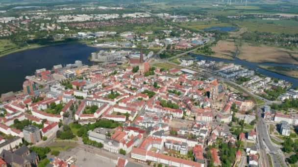 Blick aus dem Hochwinkel auf die Stadt. Historischer Stadtkern mit mehreren Kirchen. Warnow fließt durch die Stadt — Stockvideo