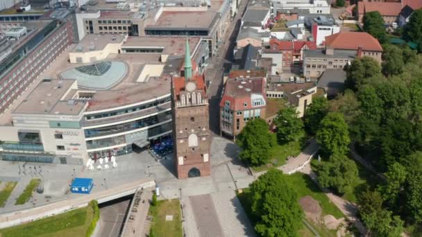 Aerial view of historic town gate Kropeliner Tor next to modern building of shopping centre. Tilt up reveal of city centre — Stockvideo