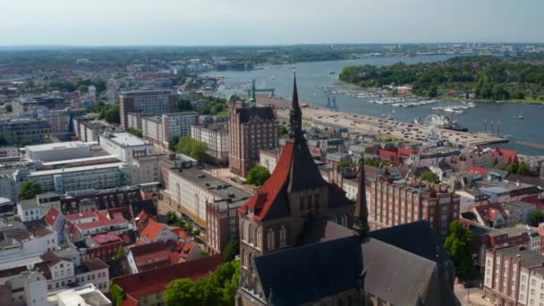 Backwards mengungkapkan bata bergaya gothic gereja Saint Marys. Panorama pemandangan udara kota tergeletak di tepi sungai yang luas — Stok Video