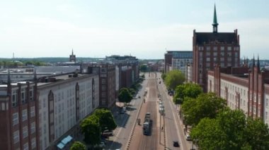 Geniş caddenin üzerinde devasa binalarla çevrili ileriye doğru uçar. Şehir panoramasında yükseliş