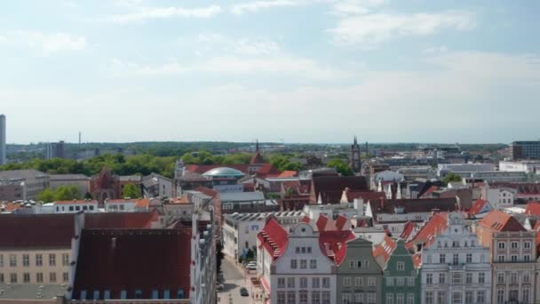 Forwards reveal of historic city centre. Square with typical colourful gabled houses and people walking on Kropeliner street — Stockvideo