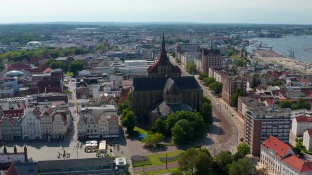 Panoramic aerial view of historic city centre with Saint Marys church. Wide straight street with tram tracks surrounded with large buildings — Stockvideo