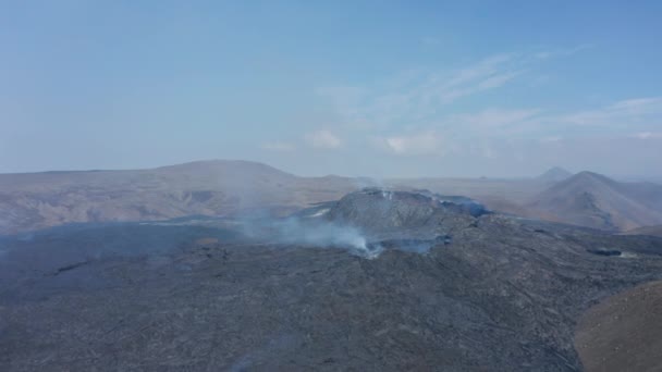 壮大なFagradalfjall火山の風景の上を飛ぶ空中ドローン、火山溶岩からの発煙、アイスランド、一日 — ストック動画
