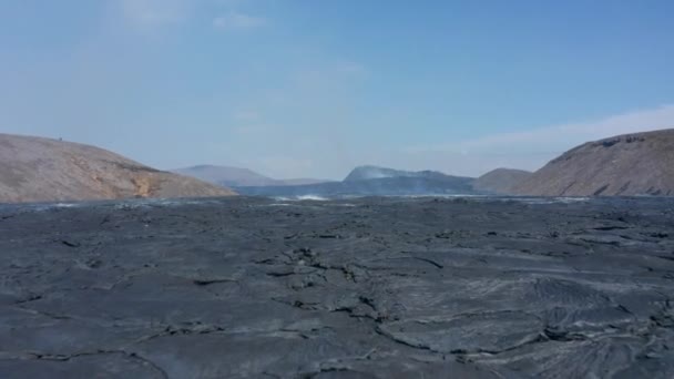 Drone aereo che vola basso sopra il vasto lago di lava nera a Fagradalsfjall, Islanda, avanti, giorno — Video Stock