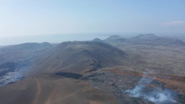 Воздушный беспилотник вид исландских гор в окружении черной лавы Fagradalsfjall извержение трещины, вперед, Исландия, солнечный день — стоковое видео