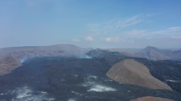 Воздушный беспилотник с видом на вулкан Фаградальсфьоль, ландшафтный покров с черной лавой, беспилотник, летящий вперед к дымному конусу, Исландия, день — стоковое видео