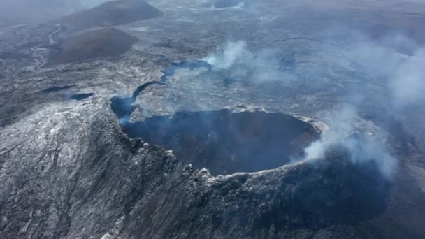 Vedere cu drone aeriene din altă lume a peisajului de lavă vulcanică afumată, drona care zboară înapoi dezvăluie conul de crater Fagradalsfjall, Islanda, ziua însorită — Videoclip de stoc