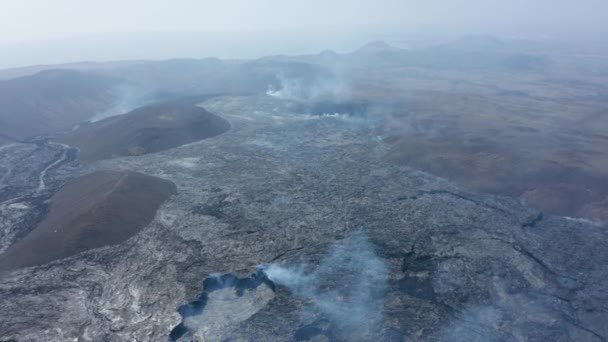 Vysoký letecký pohled na sopečné lávové jezero ve Fagradalsfjall, dron letí pozpátku směrem ke kuželu kráteru sopky, poloostrov Reykjanes, Island, slunečný den — Stock video