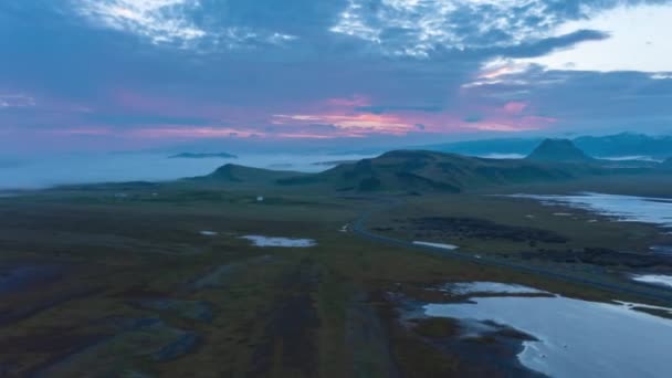 Voorwaarts vliegen boven rustige ochtend bewaard landschap in IJsland. Overtollige beelden uit de lucht van wolken die zweven in de schemerlucht en door mist overstroomde valleien in de verte — Stockvideo