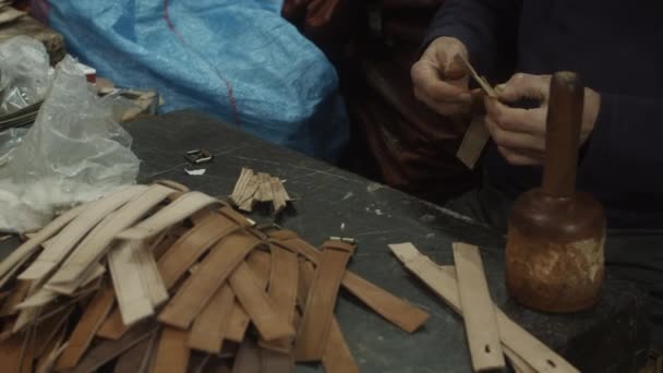 Beskuren bild av manliga händer som producerar läderbälte med gamla verktyg. Traditionell handgjord process i gammal fabrik. Marocko, Afrika — Stockvideo