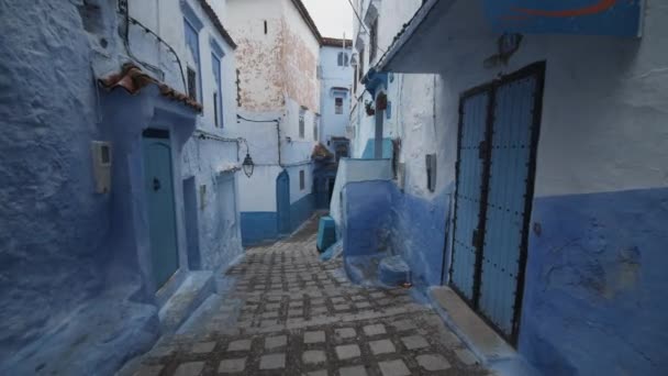 Scendendo le scale in una stradina blu della città di Chefchaouen. Vecchi edifici tradizionali con facciate dipinte di blu. Marocco, Africa — Video Stock