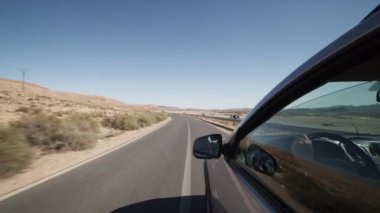 Kuru ve çorak arazide boş bir yolda araba sürmek. Dışarıdan, arka kapının yanına bak. Fas, Afrika 'ya yolculuk