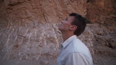 Dar geçidi yol ile çevreleyen devasa kayalık yığını hayranlıkla seyreden bir adamın yörüngesinde dönüyordu. Yolda yürüyen bir adamın arka görüntüsü. Fas, Afrika