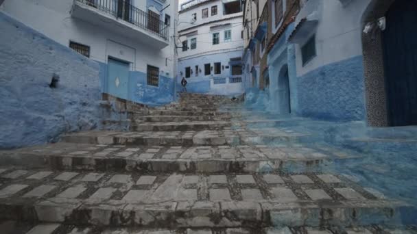 Mavi şehir Chefchaouen 'de merdivenlerin üstünde alçak uçuş. Mavi yüzlü eski geleneksel binalar. Fas, Afrika — Stok video